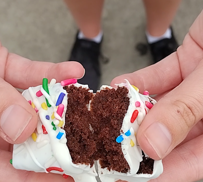 Close-up photo of hands holding a white chocolate brownie bite open.