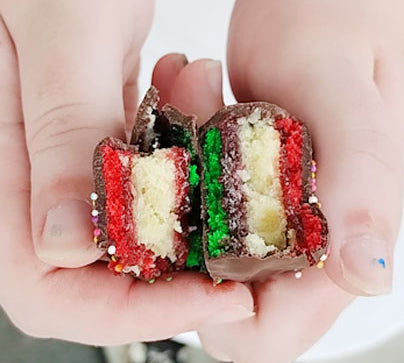 Close-up photo of hand's holding a rainbow cookie open.