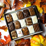 Open gift box of seasonal Fall Combo brownie and blondie bites surrounded by autumn leaves and a pumpkin, available for a limited time with nationwide shipping.