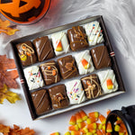 Nettie’s Bakery Halloween Combo gift box featuring chocolate-covered Candy Corn Blondie Bites, Reese’s Pieces Brownie Bites, Caramel Pecan Brownie Bites, Classic Brownie Bites, and White Chocolate Brownie Bites. Gift-ready Halloween treats available for nationwide shipping, pictured with autumn leaves and candy corn.