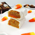 Nettie’s Bakery Candy Corn Blondie Bite cut in half and stacked to reveal its buttery blondie center, coated in white chocolate and topped with candy corn—a seasonal Halloween treat available for nationwide shipping.